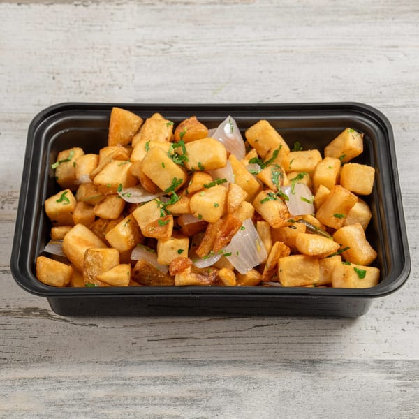 Crispy golden home fries with diced onions and fresh parsley in a black container.
